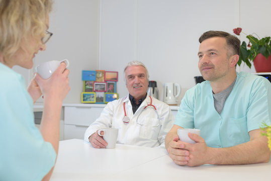 male and female doctors talking to nurse on work break