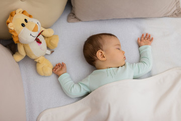 Adorable baby sleeping at night. Little girl in pajama taking a nap in dark room with toy / Baby Sleeping on the bed © miladavidovic