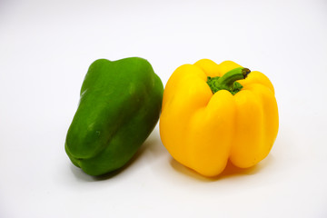 Green and yellow peppers on white background