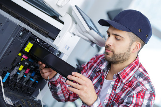 man repairing a printer at work
