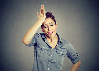 Funny silly woman slapping hand on head having duh moment