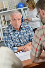 Man in meeting with couple, bemused facial expression