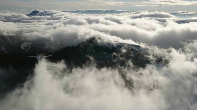 Beautiful waves of low clouds flows in winter mountains time lapse