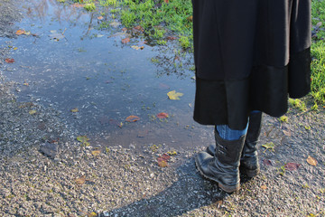 Girl Feet next to the puddle. autumn time