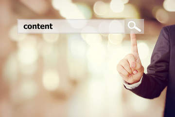 Businessman hand touch search bar with content word over blur ba