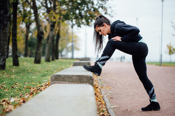 Woman runner stretching legs before run.