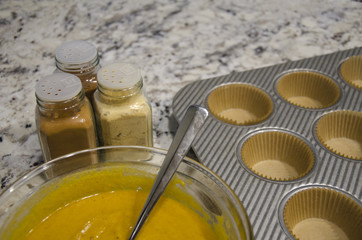 Spices and batter to bake pumpkin muffins.