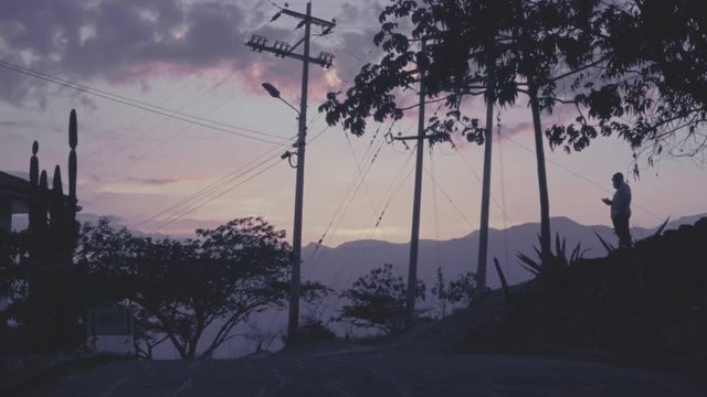 Silhouette of man on the hill of the beautiful town of Barichara, Colombia at sunset. Slow motion.