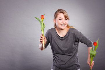 Playful girl having fun with flowers tulips.