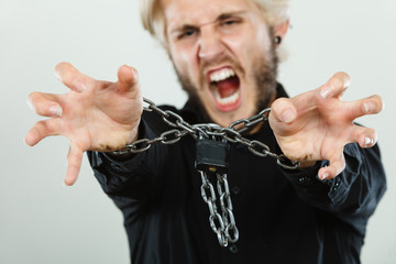 Fototapeta na wymiar Screaming man with chained hands, no freedom