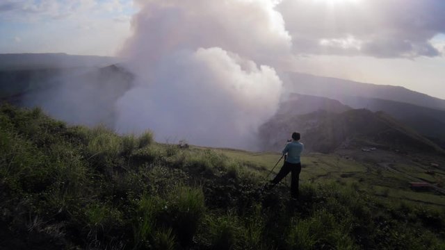 Female photographer taking photo of the green landscape over the National Park Volcano Masaya, Nicaragua. 4k