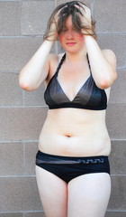 Sexy female plus size beauty posing outside in a bikini.