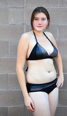 Sexy female plus size beauty posing outside in a bikini.