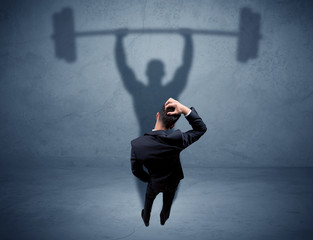 Businessman with weight lifting shadow