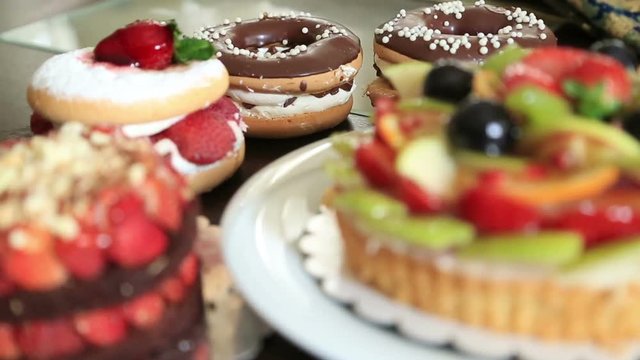 Assorted fruit tartlets, donuts and pieces of cakes