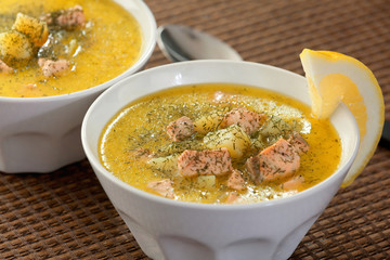 Two bowls of fish soup from salmon, potatoes, leek and sour crea
