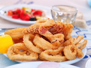 Portion of fried squid (or calamari). Greek style. Salad and win