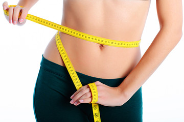 Hands measuring waist with a tape. Slim and healthy woman on white background