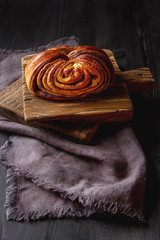Fototapeta na wymiar Fresh sweet homemade cinnamon rolls. Svedish cuisine. Dark wood
