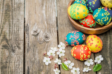 Easter eggs and flowers on wooden background