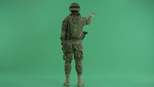Soldier moving hands standing back at green screen