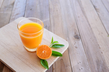 Orange juice on wooden background © sueb9872