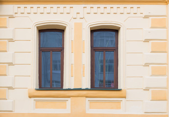 Two historic brown window on the yellow wall
