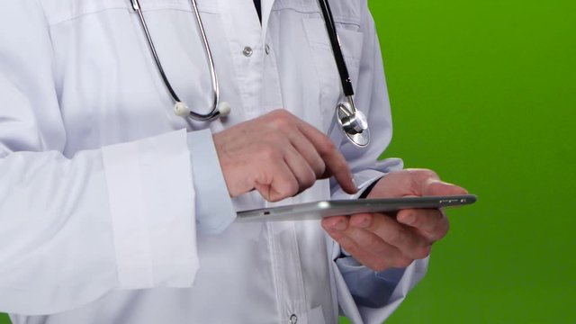 Doctor writes the patient information in the tablet pc. Green screen