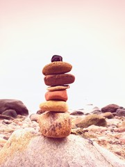 Fototapeta na wymiar Stones pyramid symbolizing zen, harmony, balance pebbles. Ocean in background