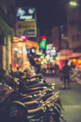 Fototapeta premium Blurred image of a lane parked with motorcycles in city at night.