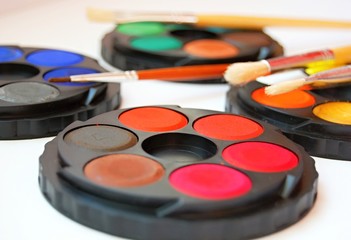 watercolor palettes and classic wooden paint brushes on white background