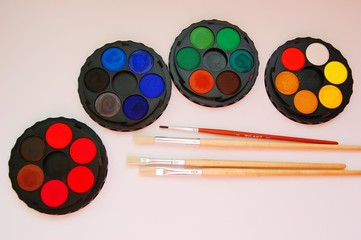 watercolor palettes and classic wooden paint brushes on white background