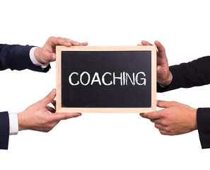 Two men holding mini blackboard with COACHING message