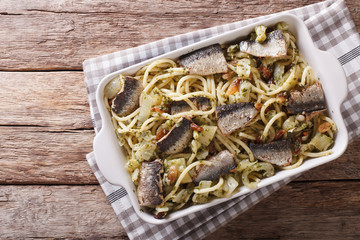 Italian food: pasta with sardines, fennel, raisins and pine nuts close up in baking dish. horizontal top view