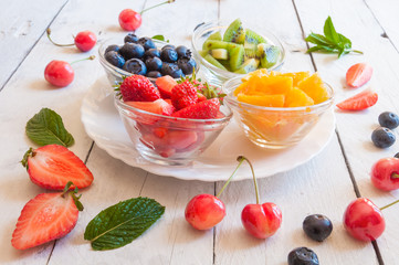 Colorful fruit salad on white table