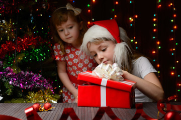 Fototapeta na wymiar Girl in santa hat opening a gift box