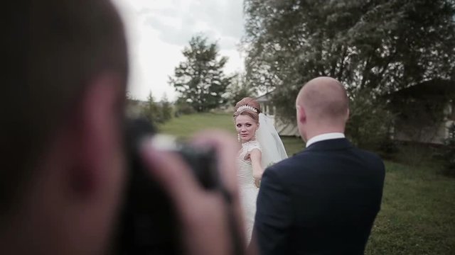 A photographer takes pictures of a beautiful young couple on their wedding day