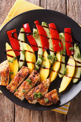 Salad with grilled chicken, mango, avocado and pepper close-up. vertical top view