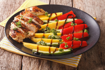 salad of grilled chicken with fresh mango, avocado, sweet pepper with balsamic sauce close-up. horizontal