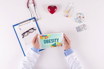 Doctor workplace with OBESITY on tablet