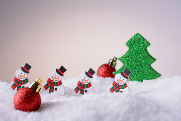 Fototapeta na wymiar Christmas toys on snow snowman, tree and balls