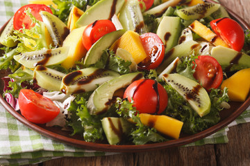 Fruit vegetable salad of mango, avocado, kiwi, tomato and lettuce close-up. horizontal
