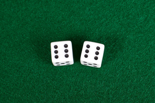 White dices on green table.