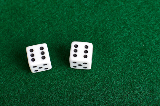 White dices on green table.