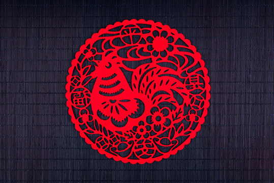 Silhouette of rooster on black bamboo mat, copy space, Chinese New Year 2017 symbol