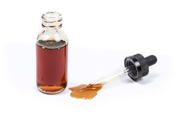 Assorted flavors vape juice and eyedropper being used isolated on white background