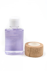 Small container of hand sanitizer and bandage isolated on white background