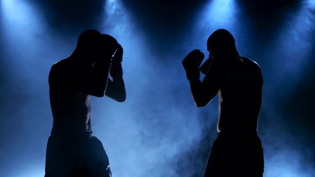 Boxing two young sportsman in a smoky studio in silhouette