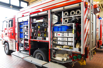 Feuerwehrausrüstung im Feuerwehrauto bei geöffneter Fahrzeughalle auf der Hauptwache