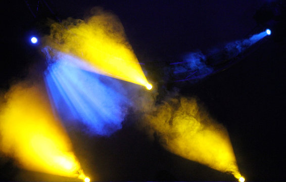 Blue and yellow colored light show over concert stage